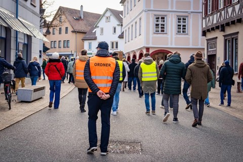 Rear view of an organiser walking through a city street, Gegen Rechts Demo, Nagold, Black Forest,