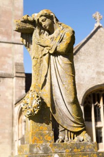 Statue on grave in graveyard of Church of Saint Bartholomew, Corsham, Wiltshire, England, UK