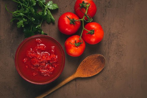 Tomatoes in their own juice, sliced, tomato sauce, tomatoes, in a cup, top view, close-up, no