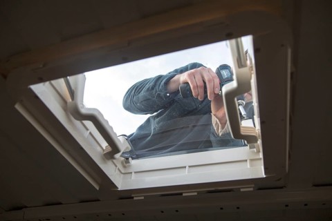 Cutting through roof of white metal camper van conversion to install ventilation window, UK