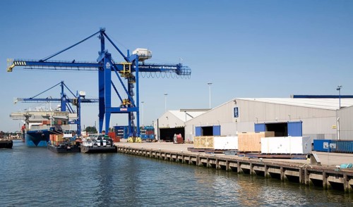 Cranes and warehouses quayside of container terminal, Port of Rotterdam, Netherlands