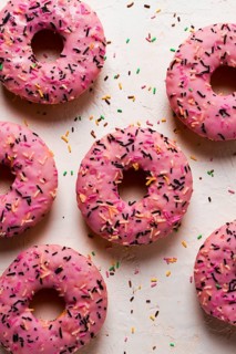 Donut with strawberries, in pink glaze, confectionery decoration, top view