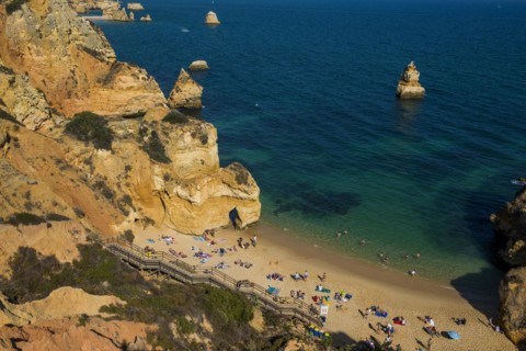 Rocky coast with beach and red rocks, Praia do Camilo, Lagos, Algarve, Portugal, Europe