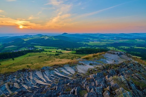Panorama of a hilly landscape at sunset, showing fields and a cloudy sky, Abtsroder Kuppe,