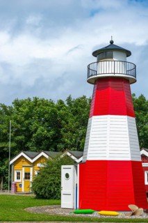 Colourful lobster shacks and lighthouse in the outdoor area of the museum with different themed