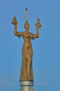 Sculpture Imperia by Peter Lenk 1993, figures, woman in outstretched arms holding two figures,