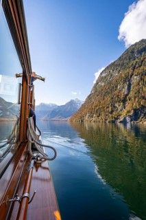 A trumpet is played on the echo wall of a tourist boat, Königssee, autumnal mountain landscape