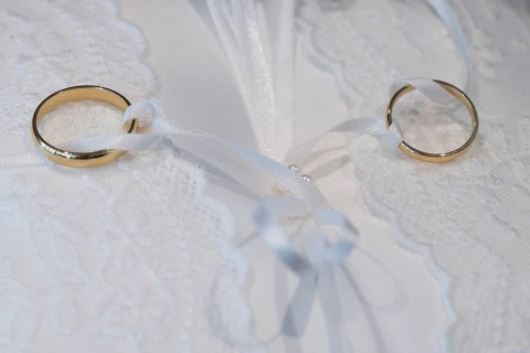 Wedding rings on an ornate white cushion