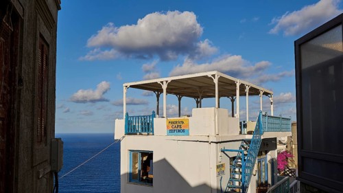 Veranda with panoramic sea view under a blue sky, with decorative railings, Colourful mountain