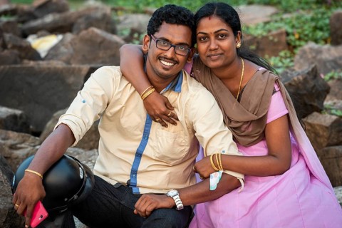 Woman hugging man with mobile phone, young married Indian couple, Fort Cochin, Kochi, Kerala, South