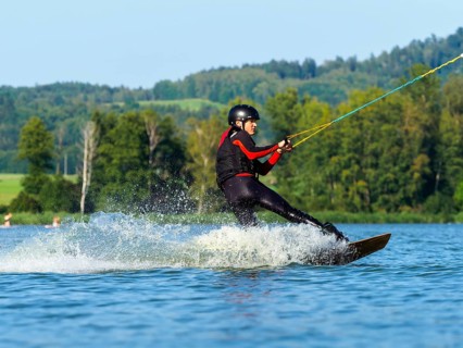 Young man doing sports with wakeboard in lake, water sports, water skiing in wakepark, Stráž pod