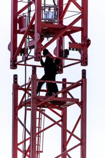 Erection of a construction crane, part of the upper crane section is hoisted by mobile crane onto