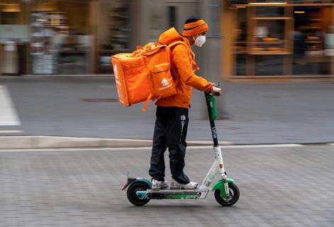 Delivery service Lieferando.de, delivery courier with e-scooter in the city centre, Rathenaustraße,