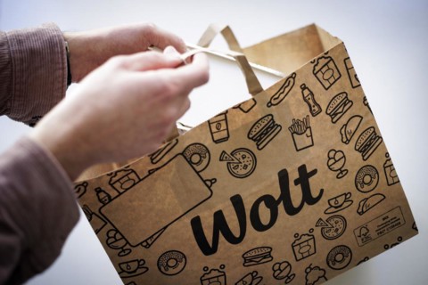 A person takes an order from a paper bag from the delivery service Wolt. Berlin, 28.03.2024