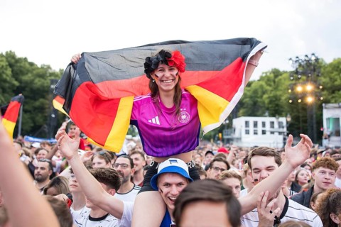Celinda celebrates with a German flag on her boyfriend's shoulders in the fan zone at the