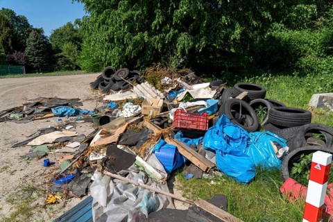Illegally disposed waste, car tyres, building rubble, household waste, clothing, on a path next to