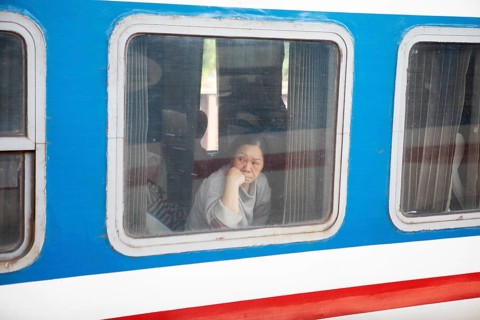 Vietnamese woman looking out of a train window, Hanoi, Vietnam, Asia