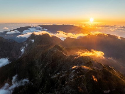 Aerial drone view of mountains over clouds near Pico Ruivo on sunset. Madeira island, Portugal,