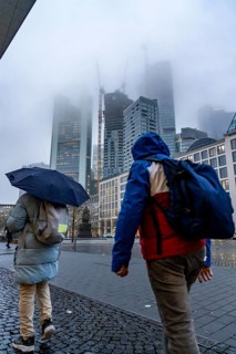 Rainy weather, freezing rain, Goetheplatz, high-rise skyline in clouds, passers-by hurrying through