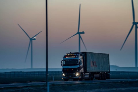 Lorry on the road to Euromax Terminal Rotterdam, ENECO wind farm on the dike around the port of