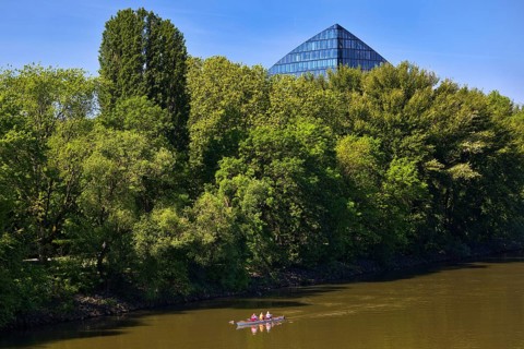 The river Main with a sports boat and the tip of the Main Triangle in Frankfurt-Sachsenhausen,