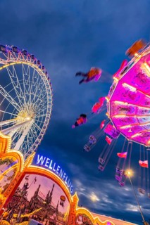 Chain carousel and Ferris wheel in the evening. 177th Cannstatter Volksfest at the Cannstatter
