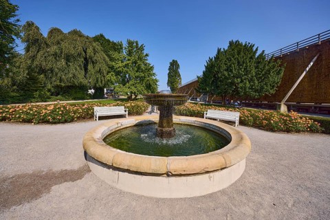 Fountain with benches, graduation tower and trees in the rose garden park in Bad Salzuflen, Lippe
