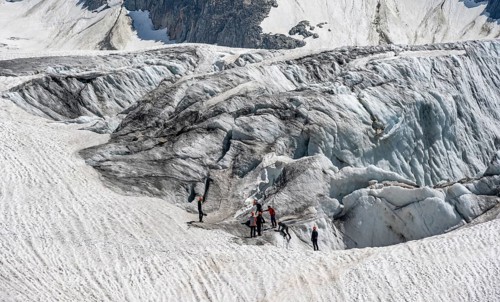 Group of mountaineers on a glacier mountaineering course, glacier ice with crevasses, Glacier du