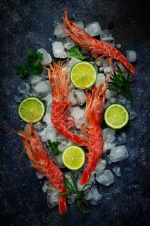 Langoustines, Australian, freshly frozen on ice, top view, lime and greens