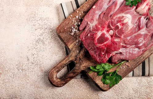 Raw steak, veal neck on the bone, fresh meat, on a cutting board, with spices, top view, without