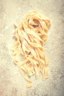 Raw tagliatelli pasta, homemade, top view, no people, rustic, food concept