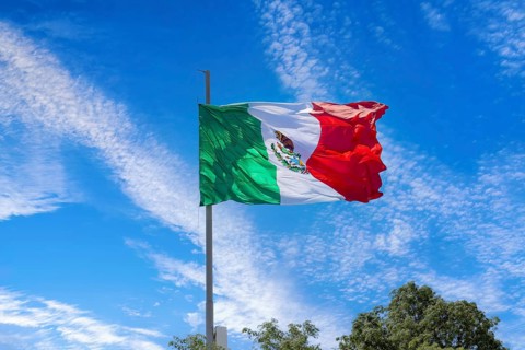 Los Cabos, Mexico, Mexican tricolor national striped flag proudly waving at mast in the air with