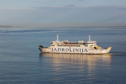 White and blue Jadrolinija Jadran Rijeka ferry boat on calm Adriatic sea leaving Port of Zadar in