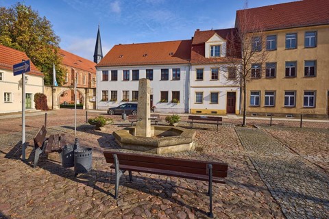 Benches with fountain, residential buildings and St Mary's Church at Altstädter Markt, Mühlberg