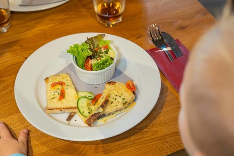 Toast with cheese and salad garnish, a child reaches for the plate, autumn creations, Cafe Kuh,