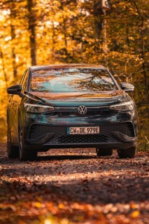 Car in autumn forest with golden leaves, electric car VW ID5, Gechingen, Black Forest, Germany,