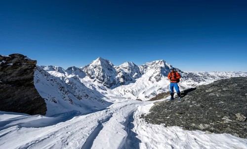 Ski tourers on foot at the summit of the Madritschspitze, mountain panorama with snow-covered
