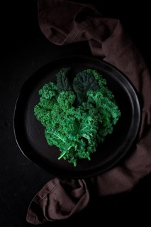 Food background, on a black table, top view, Fresh Kale leaves, close-up, vertical, no people,