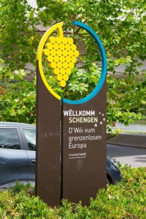 Welcome sign for Schengen with a graphic grape motif and green background, Schengen, Canton of