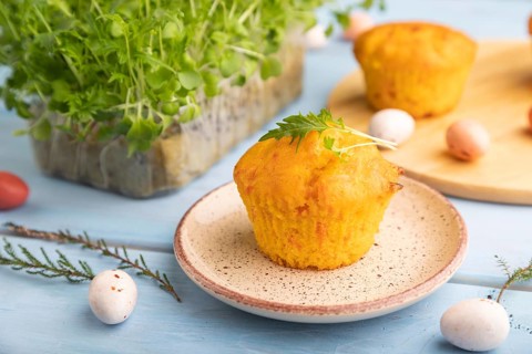 Homemade cakes with chocolate eggs and mizuna cabbage microgreen on a blue wooden background. side