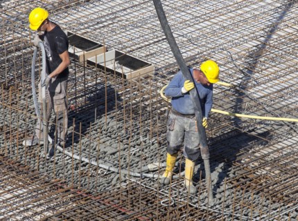 Construction workers backfilling concrete on a building site, Berlin, 19/08/2016