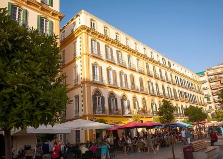 People sitting outside popular cafes on a sunny afternoon in Plaza de la Merced, Malaga, Spain,