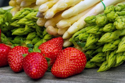 Green asparagus, white asparagus and fresh strawberries decorated on a rustic wooden table