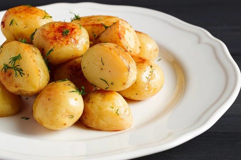 Fresh Cooked, new potatoes, with dill, on a wooden table, selective focus. close-up, toning, no