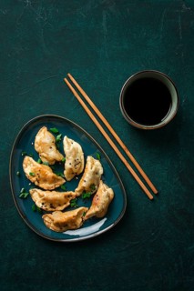 Japanese Gyoza dumplings, fried, with sauce, on a green background, top view, no people, toned,