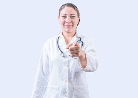 Smiling female doctor pointing at the camera. Happy female doctor pointing at you, Young doctor