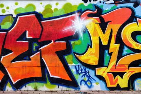 Colourful graffiti on an urban wall shows artistic lettering and vibrant colour design,