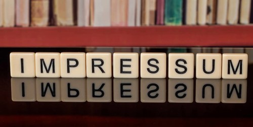The word in the IMPRINT written with letter cubes in front of a bookshelf