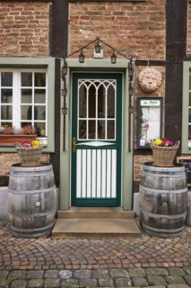 Entrance area of a restaurant in a historic half-timbered brick house with entrance door, white