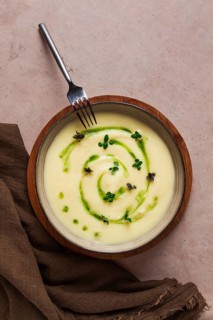 Mashed potatoes, with green butter and micro greenery, homemade, on a beige table, no people, top